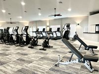 Your Gym, Just Steps from Home Modern gym with state-of-the-art cardio machines and adjustable weight benches, offering a bright and spacious workout environment.
