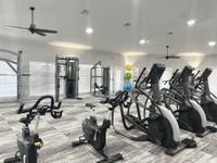 Elevate Your Workout Routine Spacious and modern gym with state-of-the-art exercise equipment, including stationary bikes, elliptical machines, and resistance stations, offering a vibrant workout environment.