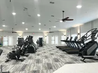 Modern Equipment, Maximum Results Modern fitness center with state-of-the-art exercise equipment, including treadmills and elliptical machines, set in a spacious, well-lit environment.