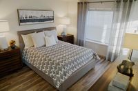 Serene Spaces for Rest and Recharge Inviting bedroom with chic decor, featuring a cozy bed, elegant artwork, and soft natural light streaming through sheer curtains.