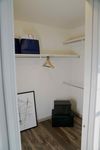 A Walk-In Worth Walking Into Chic walk-in closet with elegant wooden flooring, stylish shelving, and contemporary decor.