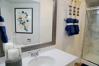 Refresh & Rejuvenate Elegant bathroom with stylish decor, featuring a modern shower, abstract wall art, and luxurious candles for a spa-like ambiance.