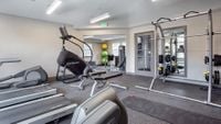 Fitness on Your Schedule Modern fitness center with state-of-the-art equipment including treadmills, StairMaster, and weightlifting area, perfect for an active lifestyle.