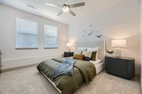 Inviting bedroom with elegant decor, featuring a plush bed adorned with stylish cushions, soft lighting from modern lamps, and artistic bird wall decorations.