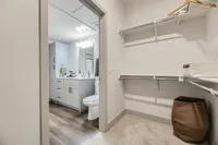 Spacious walk-in closet with elegant bathroom view, showcasing modern vanity and sleek fixtures.