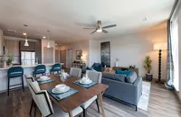 Elegant open-concept living and dining area featuring modern decor, a sleek kitchen with stainless steel appliances, and ample natural light.