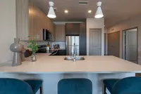Modern kitchen with sleek cabinetry, stainless steel appliances, and a spacious island with chic pendant lighting.