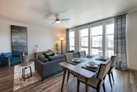 Contemporary living and dining area with stylish decor, featuring large windows, elegant furniture, and abundant natural light.