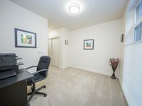 Bright home office with modern desk, ergonomic chair, stylish decor, and ample natural light from a large window.