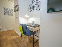 Cozy apartment corner featuring a stylish desk with modern decor, a comfortable chair, and warm wooden floors ideal for a relaxing workspace.