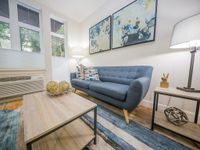 Cozy living room with a modern blue sofa, stylish abstract artwork, and soft ambient lighting.