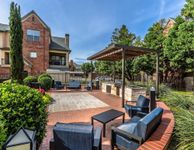 Elegant outdoor patio with stylish seating, landscaped greenery, and a modern barbecue area; perfect for entertaining in a peaceful residential setting.