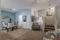 Elegant and inviting living space featuring modern decor, stylish dining area, and a cozy staircase.