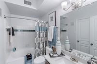 Elegant bathroom featuring a stylish vanity, modern light fixtures, and a soothing spa-like atmosphere with decorative accents.