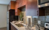 Sleek, Modern, and Functional Modern kitchen with sleek wooden cabinetry, stylish stainless steel appliances, and glossy backsplash for a sophisticated look.