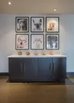 Tail-Wagging Perks Included Chic wall art display featuring dogs in glasses above a modern cabinet with pet treats.