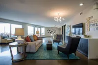 Community Starts Here Modern and spacious living room with elegant seating, vibrant cushions, and stylish lighting, offering a welcoming and luxurious atmosphere.