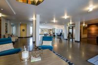 Step Into Style Luxurious and spacious apartment lobby showcasing modern seating, warm lighting, and stylish decor for a welcoming atmosphere.