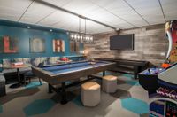 Cue Up the Fun Chic entertainment room featuring a pool table, arcade game, stylish seating, and modern decor for ultimate leisure.