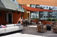 Alfresco Moments Made for You Chic outdoor patio area with modern seating, stylish shade sails, and a sleek barbecue grill, perfect for relaxation and entertaining.