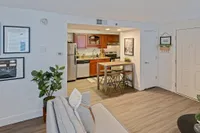 Where Function Meets Flair Chic apartment living space with a cozy kitchen, modern bar seating, stylish decor, and elegant plant accents.