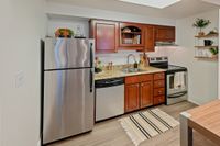 Polished. Practical. Perfect. Chic modern kitchen with stainless steel appliances, elegant wooden cabinets, and granite countertops for a sophisticated culinary experience.