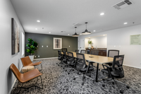 Your On-Site Office Space Modern conference room with sleek black chairs around a long table, stylish decor, and warm lighting creating a professional atmosphere.