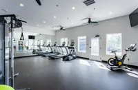 Healthier Living Has Never Been Easier Bright and modern fitness center featuring state-of-the-art treadmills and stationary bike in a spacious setting.