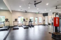 Strong Living Starts Here Modern fitness center with state-of-the-art treadmills, exercise bikes, and a punching bag, offering a spacious and well-lit environment.