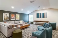 Bold, Bright, and Built to Entertain Elegant living room with a cozy sectional couch, stylish artwork, and contemporary accent chairs, creating an inviting space for relaxation.