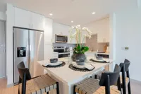 Cook in Style Modern kitchen boasting sleek stainless steel appliances, a chic island with stylish seating, and contemporary cabinetry for an elegant culinary experience.