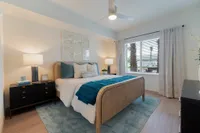 Your Sanctuary Awaits Bright and inviting bedroom with stylish decor, featuring a cozy bed, elegant nightstands, and a large window allowing natural light.