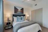 Serene Spaces for Rest and Recharge Chic and cozy bedroom featuring a plush bed with elegant cushions, stylish lamps, and modern decor.