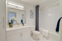 Spa-Inspired Comfort Elegant bathroom featuring a modern design with a sleek vanity, decorative wall art, and inviting bathtub with a chic shower curtain.