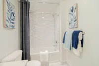 Clean, Crisp, and Contemporary Bright and modern bathroom with elegant tile design, stylish artwork, and plush towels creating a serene oasis.