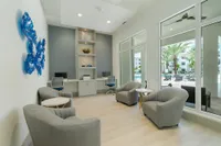 Smart Spaces for Modern Work Elegant lounge area with plush gray seating, modern design, and stunning pool view through expansive windows.