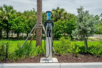 Power up, drive on with our EV Charging Station Eco-friendly EV charging station set amidst lush greenery, perfect for sustainable living enthusiasts.