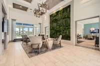A Lobby That Sets the Tone Luxurious lounge area featuring modern furniture, a striking green living wall, and elegant lighting, set in a bright, airy space with floor-to-ceiling windows.