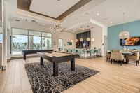 Cue Up the Fun Luxurious clubhouse interior featuring a modern pool table, chic seating areas, and a stylish breakfast bar with trendy lighting.