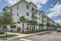 Striking Design, Inside & Out Modern apartment complex surrounded by lush palm trees, showcasing stylish balconies and a serene residential atmosphere.