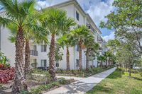 Your Private Slice of Paradise Charming exterior of a modern apartment building surrounded by lush palm trees and vibrant greenery, offering a tropical oasis feel.