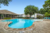 Experience relaxation at this beautifully designed poolside haven. Inviting community swimming pool surrounded by lush greenery and modern apartments, perfect for relaxation and leisure.