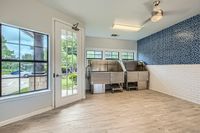 Clean Pets, Happy Homes Modern pet wash room with sleek stainless steel wash stations, large windows providing natural light, and chic blue mosaic tiles.