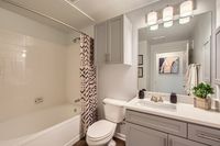 Sleep In, Stretch Out Modern bathroom featuring elegant fixtures, a chic shower curtain, stylish cabinetry, and bright lighting, perfect for relaxation.