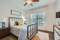 Your private sanctuary Inviting bedroom with stylish decor, featuring a cozy bed, elegant nightstands, and large window letting in natural light.