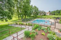 Charming outdoor swimming pool area surrounded by lush greenery and garden landscaping, perfect for relaxation and leisure.