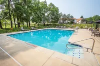 Inviting outdoor pool area surrounded by lush greenery, perfect for relaxation and leisure.
