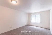 Bright and inviting bedroom in The Hampton apartment with plush carpeting and natural light, offering 1 bed, 1 bath, 630 sq. ft.