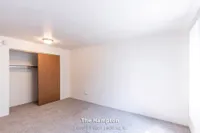Bright and spacious bedroom in The Hampton, featuring plush carpeting and a generous closet, ideal for comfortable living.