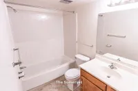 Bright and modern bathroom in The Somerset, featuring elegant fixtures, a spacious bathtub, and pristine white tiles. Perfect for relaxation in a stylish 2 Bed 1 Bath home, 970 sq. ft.